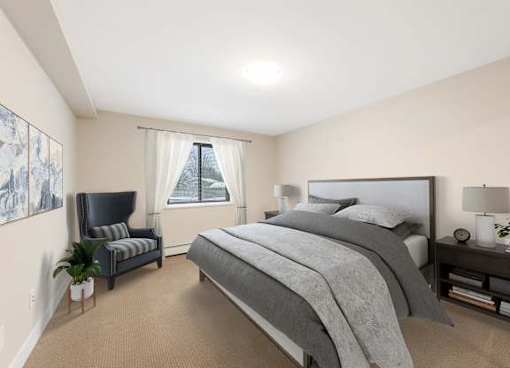 A bedroom with a large bed and a chair.