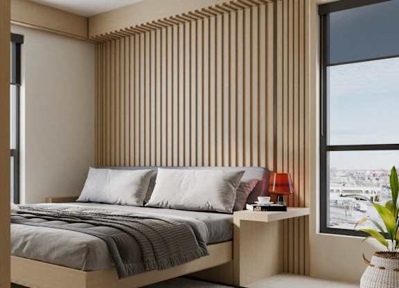 A bedroom with a bed, a nightstand, and a large window with a view of the city.