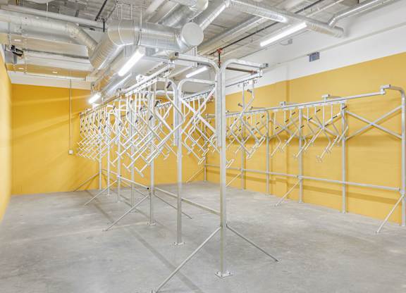 A room with a yellow wall and a metal rack system.
