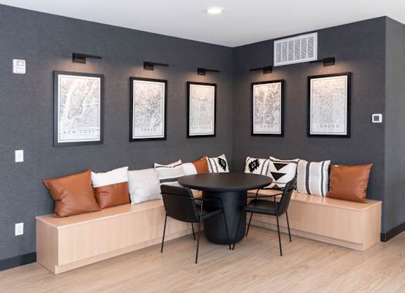 A modern living room with a black table and a bench with cushions.