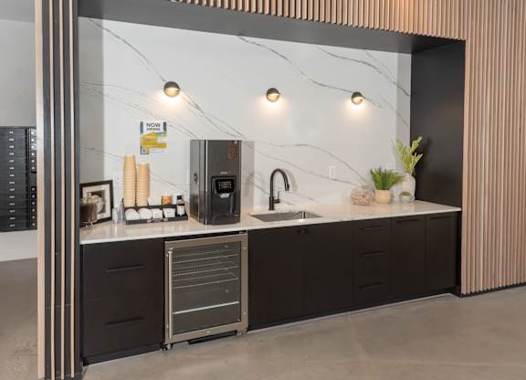 A modern kitchen with dark cabinets and a marble backsplash.