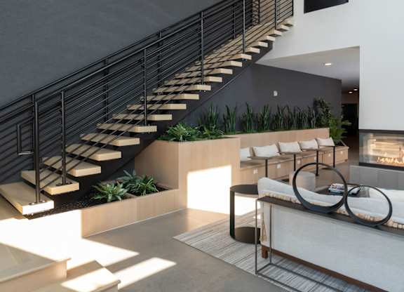 A modern living room with a staircase and a fireplace.