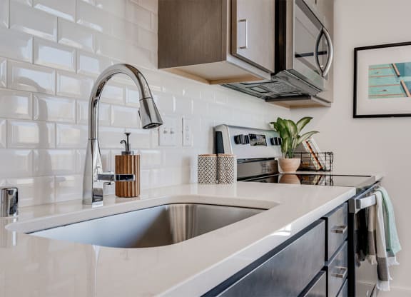 Large kitchen snick with a white brick backsplash