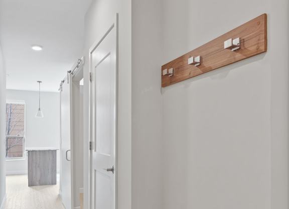 A long hallway with a wood panel on the wall.