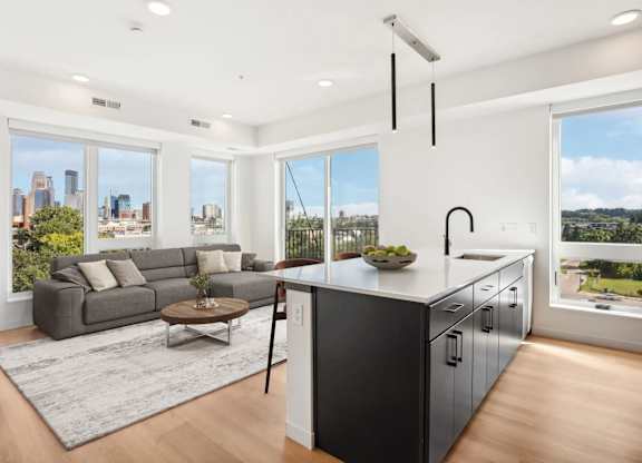 A modern kitchen and living room with a view of the city.