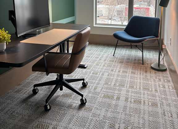 A room with a desk, chair, and a window.