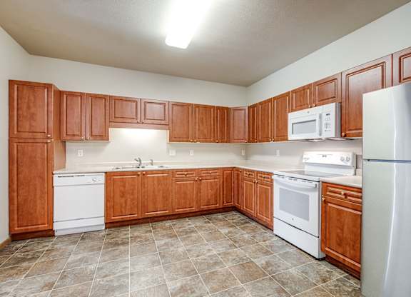 A kitchen with wooden cabinets and white appliances.