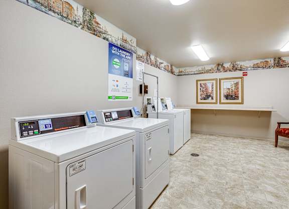 A laundromat with washers and dryers and a sign that says 