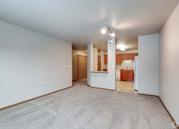 A carpeted room with a doorway leading to another room.