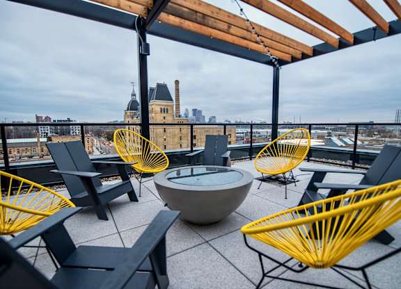 A patio with yellow chairs and a table.