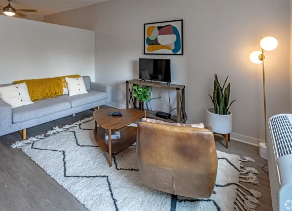 a living room with a couch and a chair and a tv