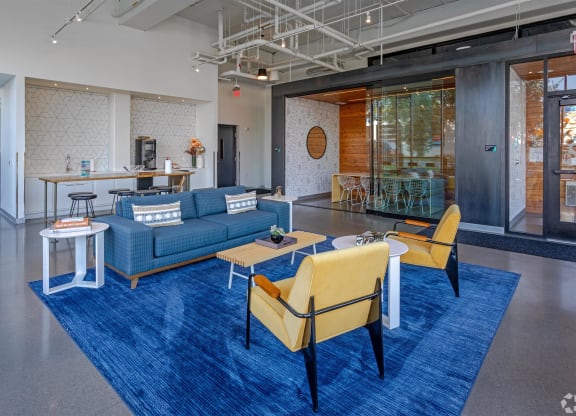 a lobby with blue couches and chairs and a blue rug