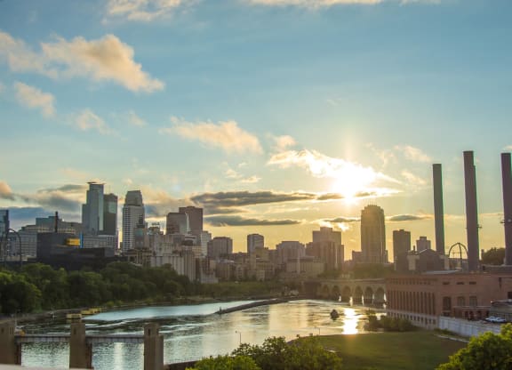 a view of the city with the sun shining over the city skyline