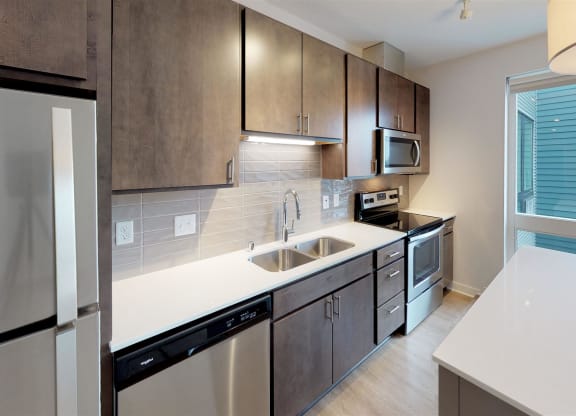 a modern kitchen with stainless steel appliances and white counter tops