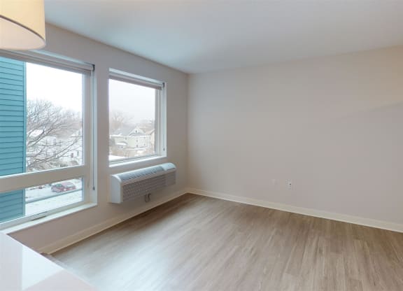 a living room with a large window and wood floors