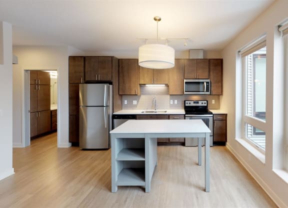 a modern kitchen with a white island and stainless steel appliances