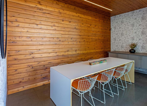 a long white conference table in a room with wooden walls