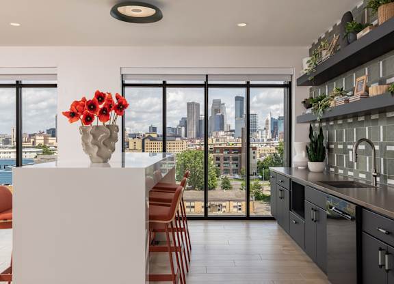 A kitchen with a view of the city skyline.