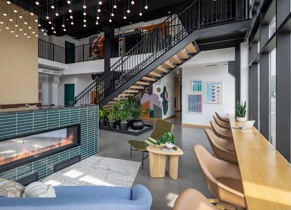 A living room with a fireplace and a staircase.