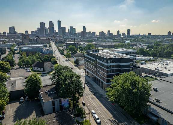 A cityscape with buildings and trees in the foreground.