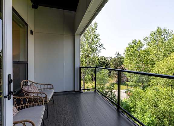 A balcony with a chair and a table.