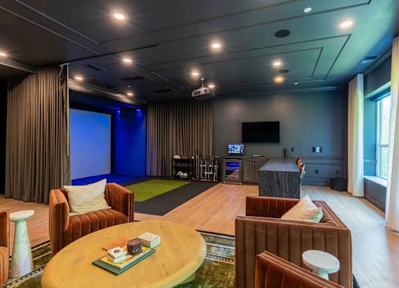 A living room with a brown sofa, a green coffee table, and a television.