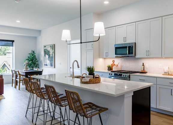 A modern kitchen with white cabinets and a large island.