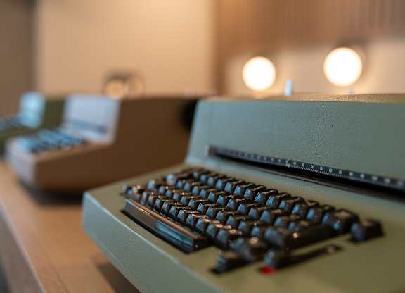 A vintage typewriter is in focus with a blurred background.