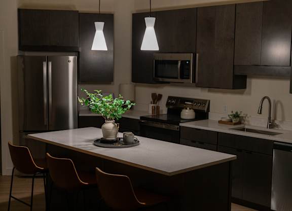 A kitchen with a table and chairs and a refrigerator.