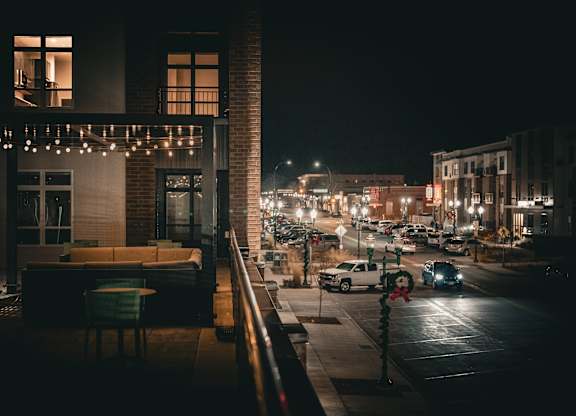 A city street at night with cars and buildings.