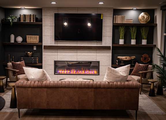 A cozy living room with a fireplace and a flat screen TV mounted above it.