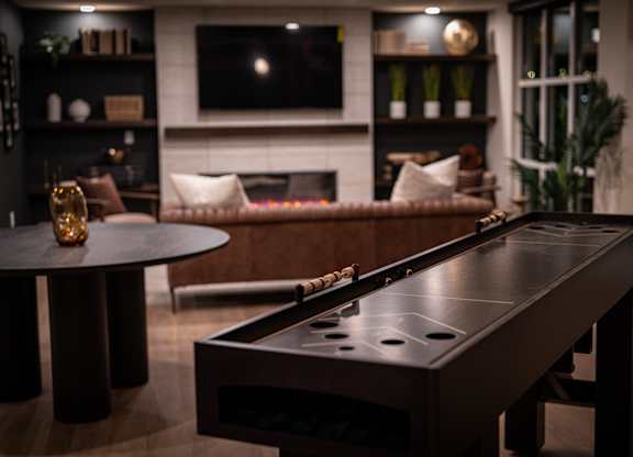 A pool table in a room with a fireplace and a couch.