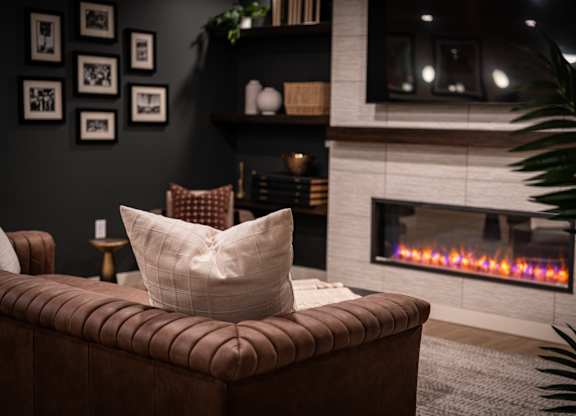 A cozy living room with a fireplace and a brown couch.