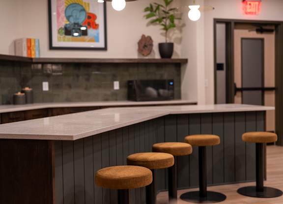 A bar with three stools in front of it.