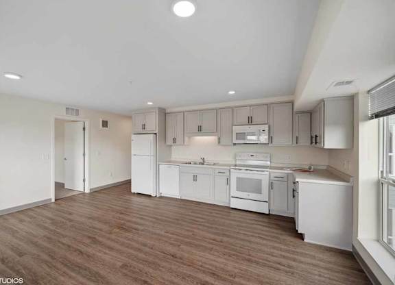 an empty room with white cabinets and appliances in it