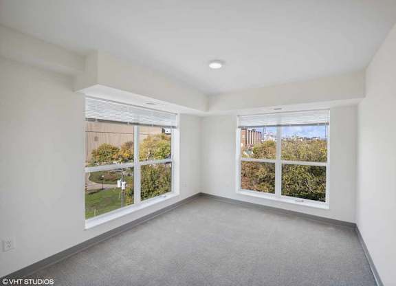 an empty living room with three windows in it