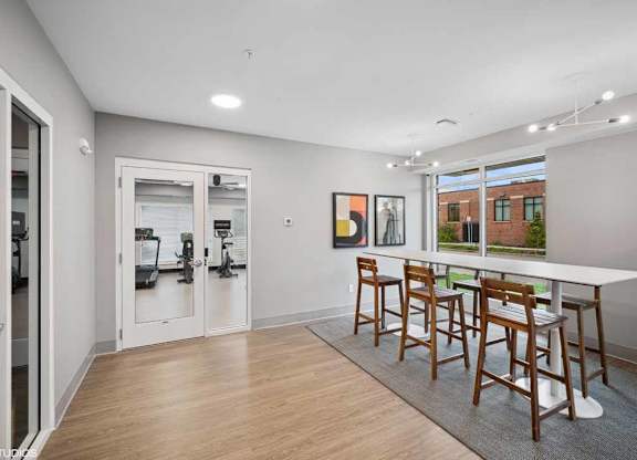 a dining room with a table and chairs in front of a window