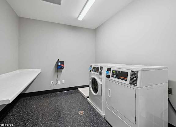 a white laundry room with a washer and a dryer