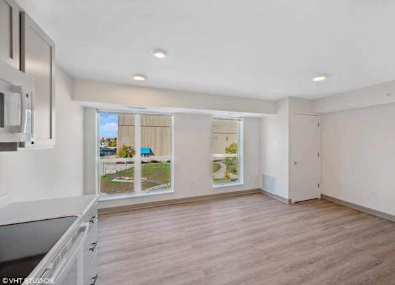an empty kitchen and living room with a large window