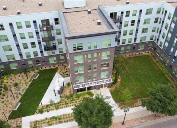an aerial view of an apartment building with a green lawn