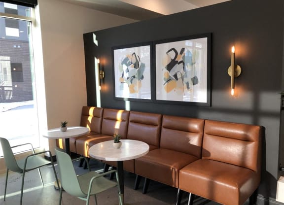 a seating area of a restaurant with leather couches and tables