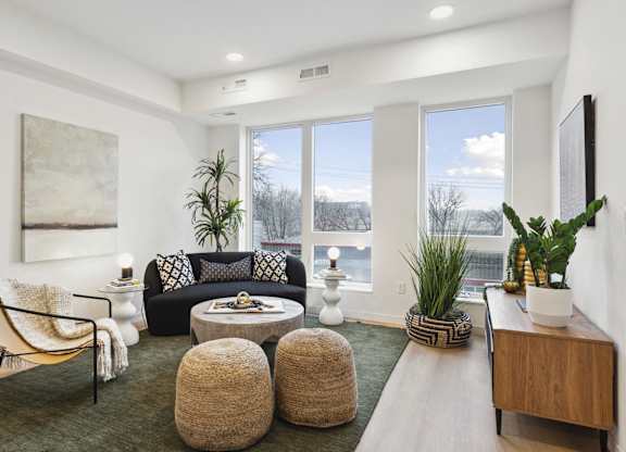A living room with a large window, a sofa, a chair, and a coffee table.
