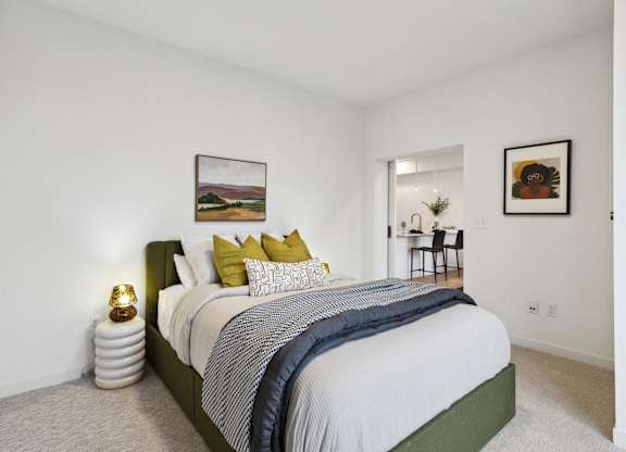 A bedroom with a large bed and a painting on the wall.