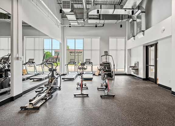 A gym with treadmills, exercise bikes, and elliptical machines.