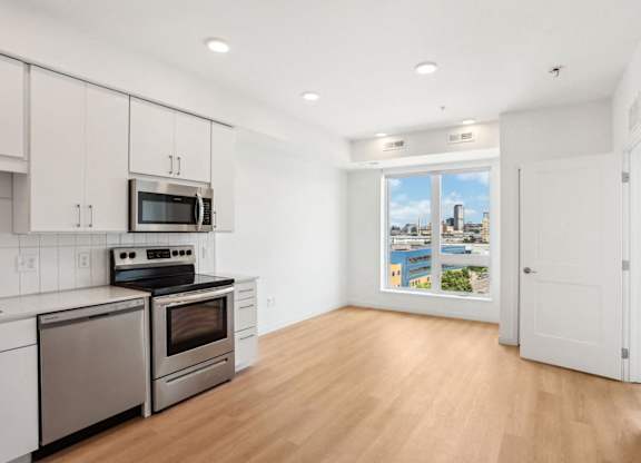 A kitchen with stainless steel appliances and wooden floors.