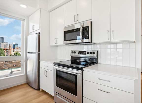 A kitchen with white cabinets and stainless steel appliances.