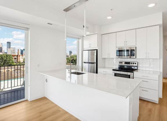 A modern kitchen with white cabinets and appliances.