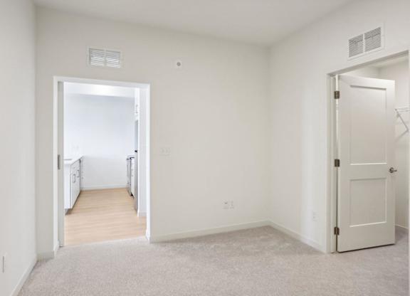 A white room with a carpeted floor and two doors.
