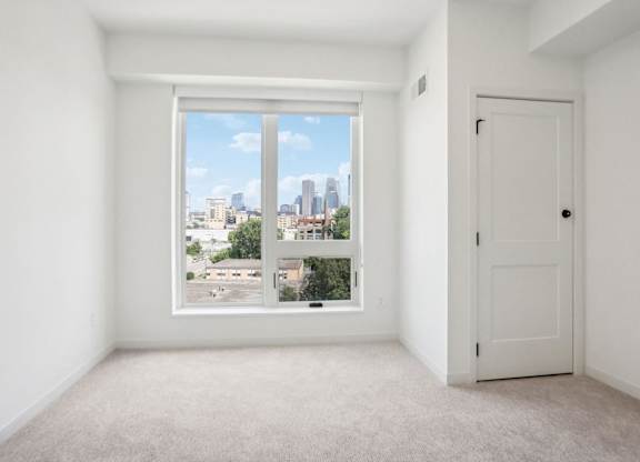 A white room with a large window overlooking a cityscape.