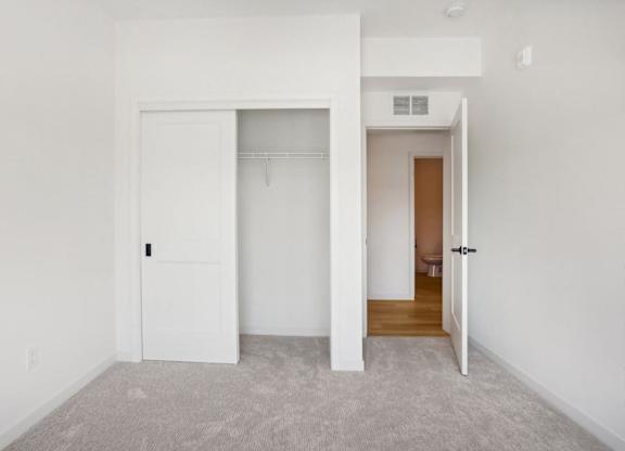 A white door is open to a room with a carpeted floor.
